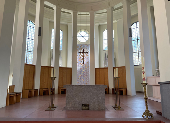 Das Hungertuch der Fastenzeit ist nun ein Ostertuch. Goldene Flächen durchziehen das Tuch hinter dem Kreuz. Je nach Lichteinfall beginnen sie zu leuchten – mal zart reflektierend, mal scheinen sie aus sich selbst heraus zu strahlend. Besonders in der Nähe des Kreuzes verdichtet sich dieses Leuchten.